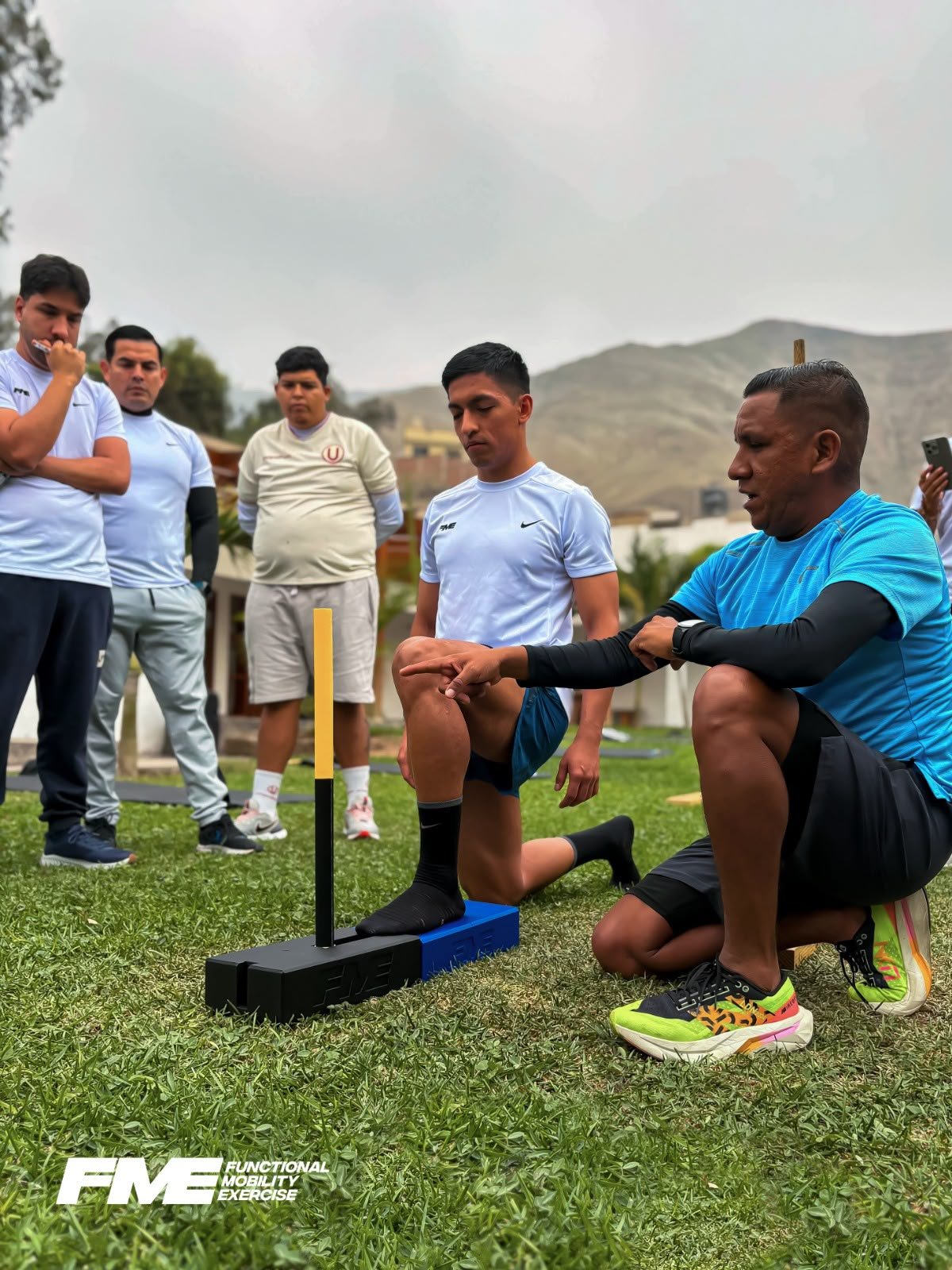 Instructor FME evaluando la movilidad de tobillo con el grupo